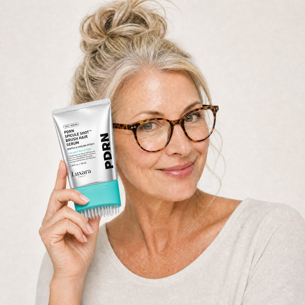Woman using the Luxara PDRN scalp brush serum