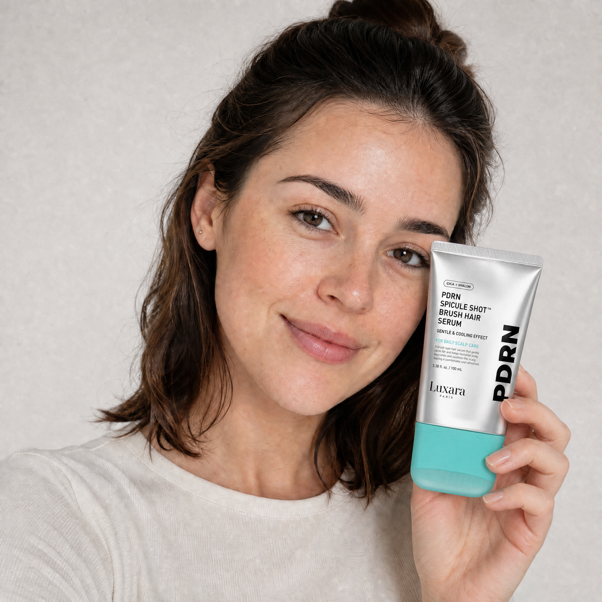 Woman using the Luxara PDRN scalp brush serum